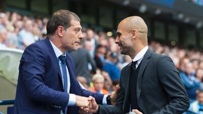 West Ham manager Slaven Bilic, left, and Manchester City manager Pep Guardiola greet each other before the match. Jon Super / AFP