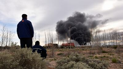 Workers from the New American Oil refinery watch smoke rising after an explosion killed several colleagues. Reuters