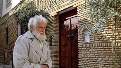 Tunisian teacher Dhouib walks past a traditional house.