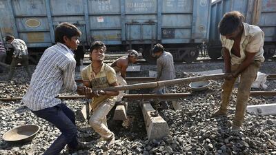 Labourers repair a railway track at a railway station in Ahmadabad. Once a pride of the Indian government, the railway sector is now hobbled by ageing infrastructure. Ajit Solanki / AP Photo