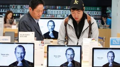 Customers in Seoul look at products behind computer monitors displaying the obituary of former Apple CEO Steve Jobs. Jobs has died after battling health problems since 2004. He resigned as Apple's chief executive six weeks ago.