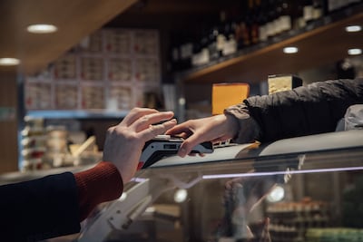 A customer uses a bank card at a contactless terminal on February 15. Bloomberg