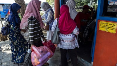 Passengers exchange plastic bottles for Suroboyo bus tickets.