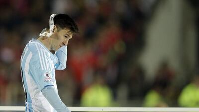 Argentina's Lionel Messi takes off the Copa America runners-up medal after losing the final against Argentina on Saturday in Santiago. Natacha Pisarenko / AP / July 4, 2015