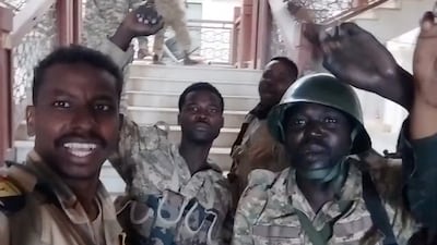 Sudanese army troops celebrate after regaining control of the presidential palace in central Khartoum on Friday. Reuters