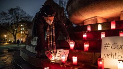 Christian Y. Schmidt picks up a candle at a makeshift memorial for Covid victims at Arnswalder Platz in Berlin, Germany. Getty Images