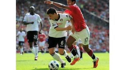 Nani, right, the Manchester United winger, tussles for the ball with Fulham defender Chris Baird at Old Trafford yesterday. The Portuguese player had a hand in both United's goals.