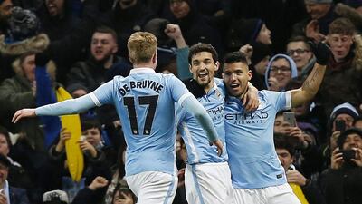 Sergio Aguero, right, celebrates with Jesus Navas and Kevin De Bruyne after scoring the goal that sent Manchester City into the League Cup final. Andrew Yates / Reuters