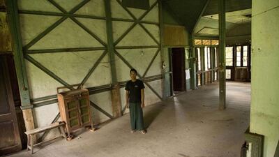 TO GO WITH AFP STORY 'MYANMAR-HISTORY-LITERATURE' by William DAVIES This picture taken on July 24, 2013 shows Myanmar artist Nyo Ko Naing standing in the house where British writer George Orwell is thought to have lived in the 1920s in Katha, a small trading post on the banks of the Irrawady river, 13 hours north of Mandalay by train. A group of artists in a remote town in northern Myanmar has launched a campaign to preserve the house. Katha and the house lived in by Orwell, known then as Eric Blair, were immortalised in the author's first novel, Burmese Days. AFP PHOTO/William DAVIES *** Local Caption *** 924113-01-08.jpg