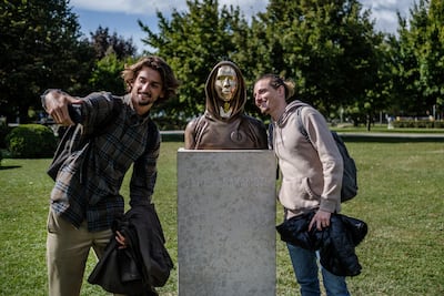 Students take selfies of a statue of Satoshi Nakamoto, a presumed pseudonym used by the inventor of Bitcoin, as it is displayed in Graphisoft Park in Budapest, Hungary. Getty