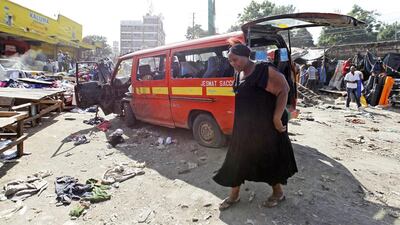 A woman walks near a damaged vehicle at the scene of a twin explosion at the Gikomba open-air market for second-hand clothes in Kenya’s capital Nairobi. Thomas Mukoya / Reuters