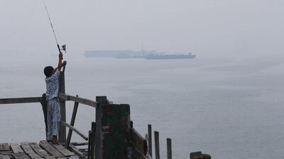 A boy fishes at a jetty, as a ship is seen in the background through haze, at Northport Klang, outside Kuala Lumpur. Local media reported unhealthy levels of air pollution with an air pollutant index (API) of 118 in some parts of the country. Samsul Said / Reuters