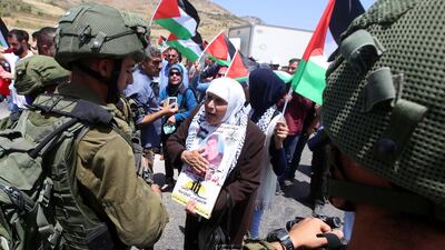 Israeli soldiers block Palestinians protesting in support of Palestinian prisoners on hunger strike in Israeli jails, at Huwwara checkpoint, near the West Bank city of Nablus, on May 11, 2017. Alaa Badarneh / EPA