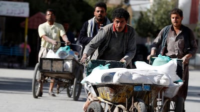 People push wheelbarrows with food rations provided by the World Food Programme at an aid distribution centre in Sanaa, Yemen. EPA