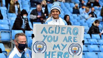 A Manchester City fan with a sign for Sergio Aguero in May 2021. PA