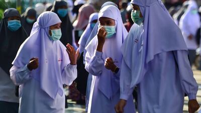 Students wearing face masks talk in the Attarkiah Islamic School in the southern Thai province of Narathiwat as schools across Thailand reopened after being temporarily closed to concerns about the novel coronavirus. AFP