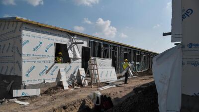 Builders work on the construction site of the refugee camp of Ritsona, some 80km north of Athens, where housing facilities are being expanded. AFP