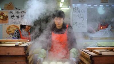 A vendor prepares Korean "mandu" dumplings at a market in Seoul on December 11, 2014. South Korea's jobless rate inched down in November from a month earlier, with new jobs being created in a number of service and manufacturing industries, government data showed on December 10. Ed Jones / AFP