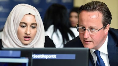 British prime minister David Cameron speaks with Zahra Qadir during a workshop about ways to report suspicious on-line activity. Paul Ellis / AFP