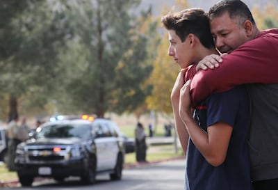 Marco Reynoso hugs his son, 11th grader Dylan Reynoso after reuniting at a park near Saugus High School after a shooting at the school left two students dead and three wounded. Mario Tama/ Getty/ AFP