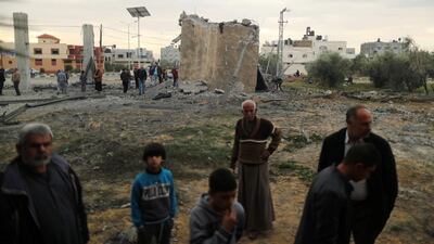 Palestinians gather around the remains of a building. Reuters