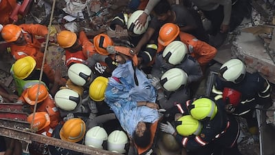 Personnel rescue a survivor. AFP