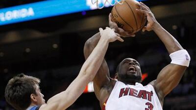 Miami Heat's Dwyane Wade shoots against Minnesota's Alexey Shved.
