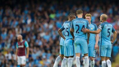 Manchester City defender John Stones talks to teammates ahead of being substituted. Jon Super / AFP