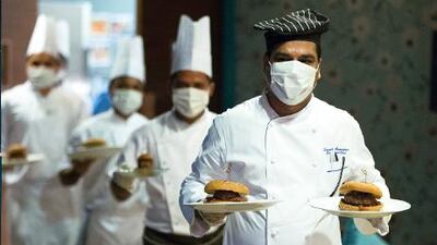 Chefs don surgical masks to promote the burger claimed to be the region’s spiciest, which goes on sale today. Photo courtesy Qube Sports Bar