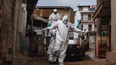 Uganda Red Cross Society workers in protective gear are sprayed with disinfectant during the evacuation of the body of a suspected Ebola victim in Kampala on May 26. AFP