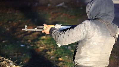 A member of the Kurdish People's Protection Units (YPG) militia stands guard in fields outside the Kurdish town of Jandairis, near the Syrian-Turkish border, west of the city of Afrin, on January 26, 2018. AFP