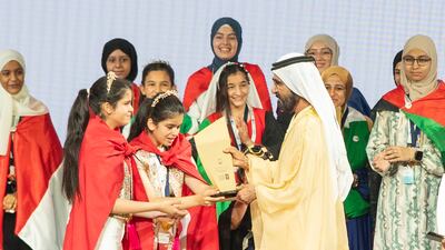 Sheikh Mohammed bin Rashid with the joint winners of the Arab Reading Challenge, twin sisters Baisan and Baylsan Koka. Ruel Pableo for The National