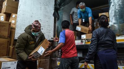 Workers unload boxes containing vaccine doses donated by the US in Kathmandu, Nepal. AFP