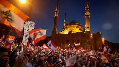 Lebanese anti-government protesters wave the national flag during a demonstration in downtown Beirut against the ruling elite deemed corrupt. Afp