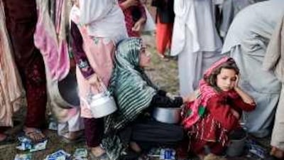 Young girls displaced by the military operations queue for rations in a relief camp in Mardan.