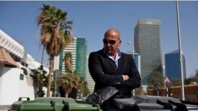 Tareq Altan with his family's recycling bins - green for recyclable waste, black for other rubbish - outside his home in the Khalidiya area of Abu Dhabi. Mr Altan's family recycle their household waste. Silvia Razgova / The National
