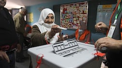 An elderly Palestinian woman casts her vote at a polling station during municipal elections in the village of Deir Al Hatab, east of the occupied West Bank city of Nablus. Getty Images