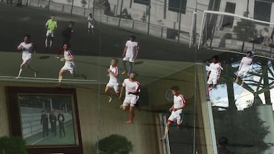 North Korean football players training in a field are reflected on a glass window in Pyongyang, North Korea. How Hwee Young / EPA