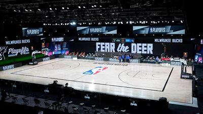 Officials stand beside an empty court at the scheduled start of an NBA basketball first round play-off game between the Milwaukee Bucks and the Orlando Magic, on Wednesday, August 26. The Bucks called off the fixture in protest against the shooting of Jacob Blake, a black man, by police in Kenosha, Wisconsin, near Milwaukee. AP