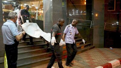 Malian officials carry a corpse outside the Radisson hotel in Bamako, Mali, on November 20, 2015. The country has begun three days of national mourning and declared a state of emergency. Joe Penney/Reuters