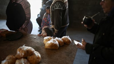 A child looks over a table displaying bagged cereals for exchange, as soup kitchens, barter clubs and families taking out short-term loans for groceries are exposing the social strains emerging under Argentine President Javier Milei's austerity program. Reuters