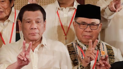Moro Islamic Liberation Front chairman Murad Ebrahim, right, and Philippine President Rodrigo Duterte flash peace signs following oath-taking ceremony for the creation of the Bangsamoro Transition Authority (BTA) at the Presidential Palace in Manila. AP