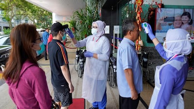 Nurses check the temperatures of visitors as part of the coronavirus screening procedure at a hospital in Kuala Lumpur. AP Photo