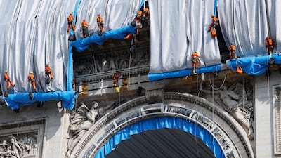 Workers unravel silver-blue fabric. AFP
