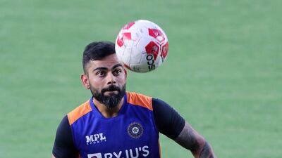 India's Virat Kohli warms-up with a football. PA