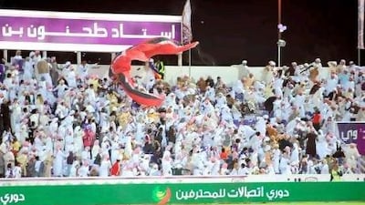 Football fans flee in panic at the moment a paraglider and its engine crashed into a stand at the Tahnoun bin Mohammed Stadium in Al Ain last night.