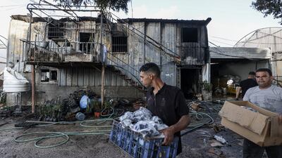 Men retrieve items from an attack on a plant nursery in the village of Deir Sharaf, west of Nablus, in September. AFP