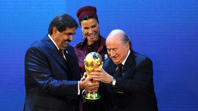 Emir of the State of Qatar Sheikh Hamad bin Khalifa Al-Thani (R) and his wife Sheikha Moza bint Nasser Al-Missned (C) receive the World Cup trophy from Fifa President Sepp Blatter after the announcement that Qatar will host the 2022 World Cup. Blatter now says it should go to the USA. AFP