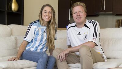 Sebastian and Karin Haase in their German and Argentinian football shirts at their home on the Corniche in Abu Dhabi. Mrs Haase said although her husband said he would be happy if Argentina won, he was “90 per cent for Germany and 10 pr cent for Argentina”. Antonie Robertson / The National