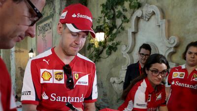 Sebastian Vettel signs a cap at Abu Dhabi theme park Ferrari World's anniversary celebrations. Ravindranath K / The National